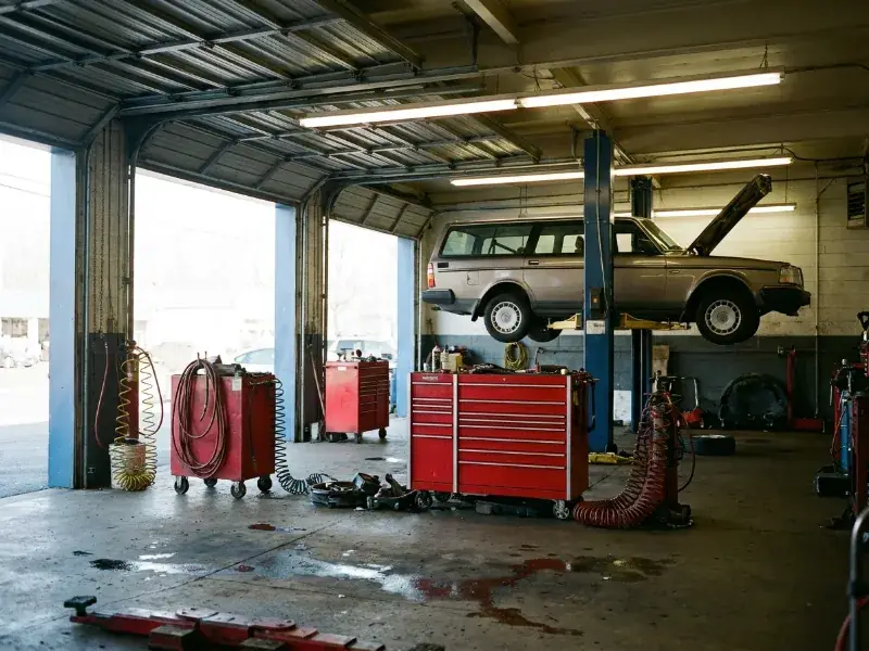 The interior of an independent New Jersey auto repair garage with a car on the lift